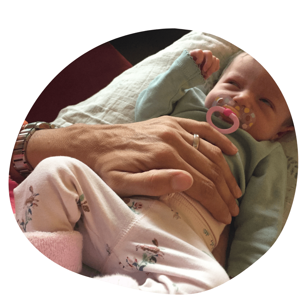 Baby liegt in einem Kuschelkissen und wird osteopathisch behandelt - Kinderbehandlung in der Osteopathie